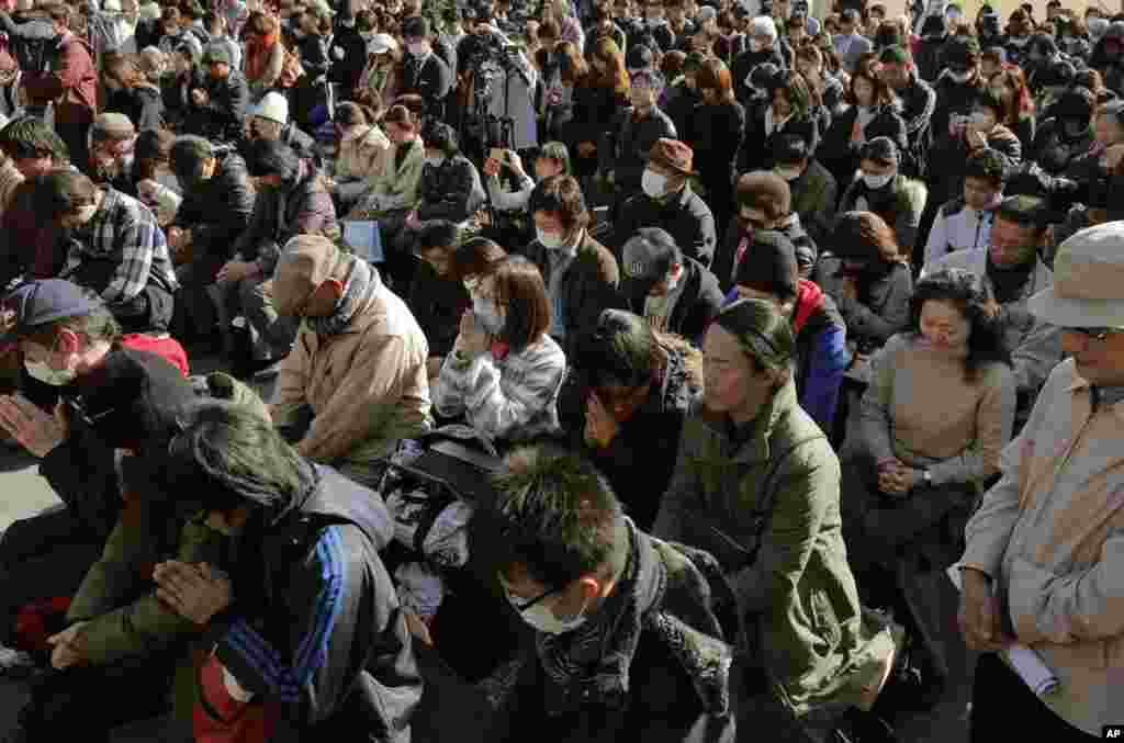 Warga di Tokyo mengheningkan cipta bagi para korban gempa dan tsunami 11 Maret 2011. (AP/Itsuo Inouye)