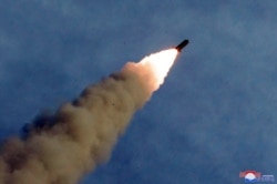 A missile is fired during the test of a multiple rocket launcher in this undated photo released, Aug. 25, 2019, by North Korea's Korean Central News Agency.