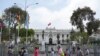 ARCHIVO - Personas pasan frente al Congreso durante una visita de una delegación de la OEA en Lima, Perú, el lunes 21 de noviembre de 2022.