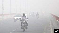 Motorists drive surrounded by smog, in New Delhi, India, Nov. 8, 2017.