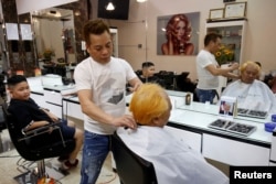 To Gia Huy (kiri) dan Le Phuc Hai sedang potong rambut gaya Pemimpin Korea Utara Kim Jong Un dan gaya Presiden AS Donald Trump di Hanoi, Vietnam, 19 Februari 2019.