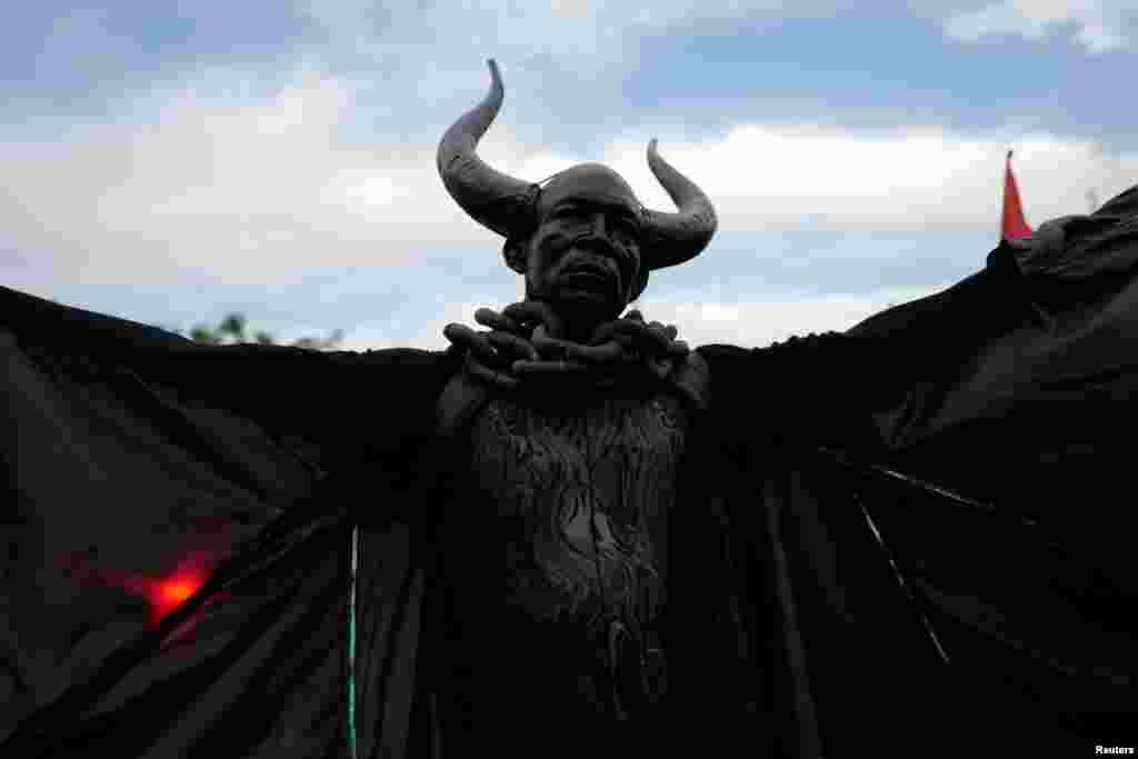 A man dressed as the "Bat King" walks down the street as he takes part in the overnight-into-dawn celebration called J'Ouvert, ahead of the annual West Indian-American Carnival Day Parade in Brooklyn, New York, Sept. 5, 2016.