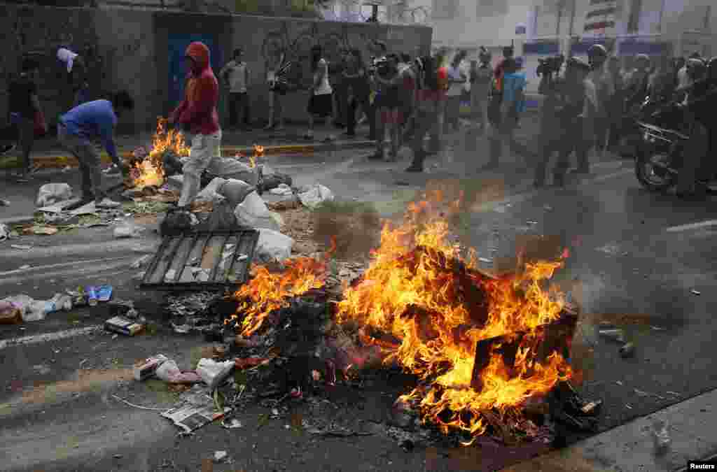 Supporters of opposition leader Henrique Capriles block a street by setting fire to what ever they can find while demonstrating for a recount of the votes in Sunday's election, in Caracas, April 15, 2013. 