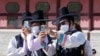 Un grupo de hombres, con mascarilla para protegerse del coronavirus, toman fotografías durante una visita al Palacio de Gyeongbok para celebrar el Chuseok, la versión coreana del Día de Acción de Gracias, en Seúl, Corea del Sur, el 22 de septiembre de 2021. 