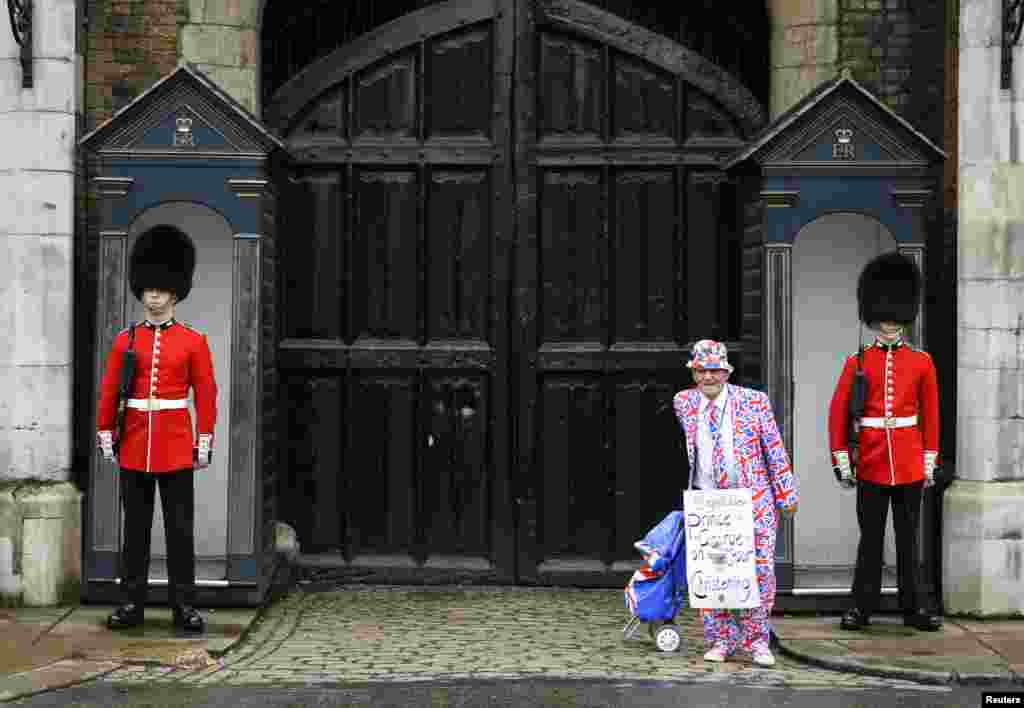 Seorang penggemar keluarga kerajaan berdiri di luar Istana St. James sebelum acara pembaptisan Pangeran George di London.