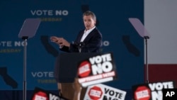 Picha inayoonyesha wapinzani wa gavana Gavin Newsom wa California wakipeperusha mabango ya kupinga uongozi wake.