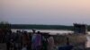 People displaced by the fighting in Bor county, stand by their belongings after arriving in the port of Minkaman, in Awerial county, Lakes state, in South Sudan, Jan. 14, 2014. 