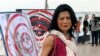 FILE - In this Nov. 18, 2012, file photo, activist Theary Seng poses with dartboard posters during a protest in Phnom Penh, Cambodia. (AP Photo/Luke Hunt, File)