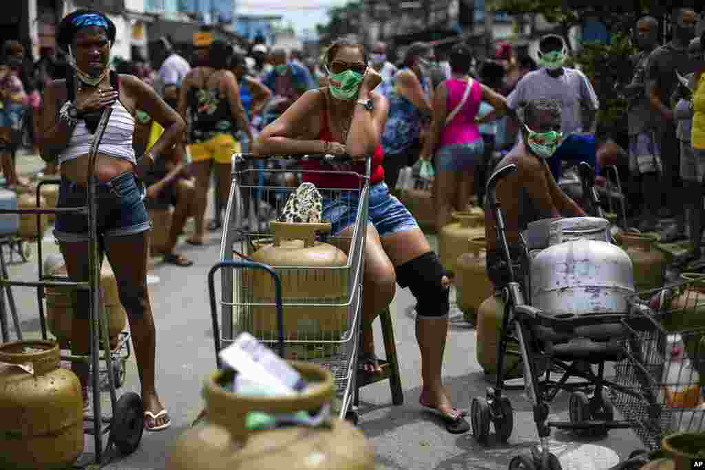 People wearing masks amid the COVID-19 pandemic wait to buy low-cost cooking gas from the Petrobrás Oil Tankers Union in the Vila Vintem favela of Rio de Janeiro, Brazil.