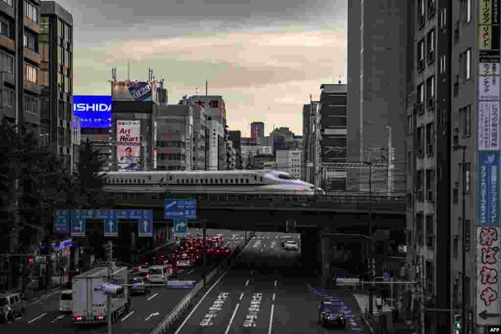 A shinkansen, or high-speed bullet train, travels through Shimbashi area of Tokyo, Japan.