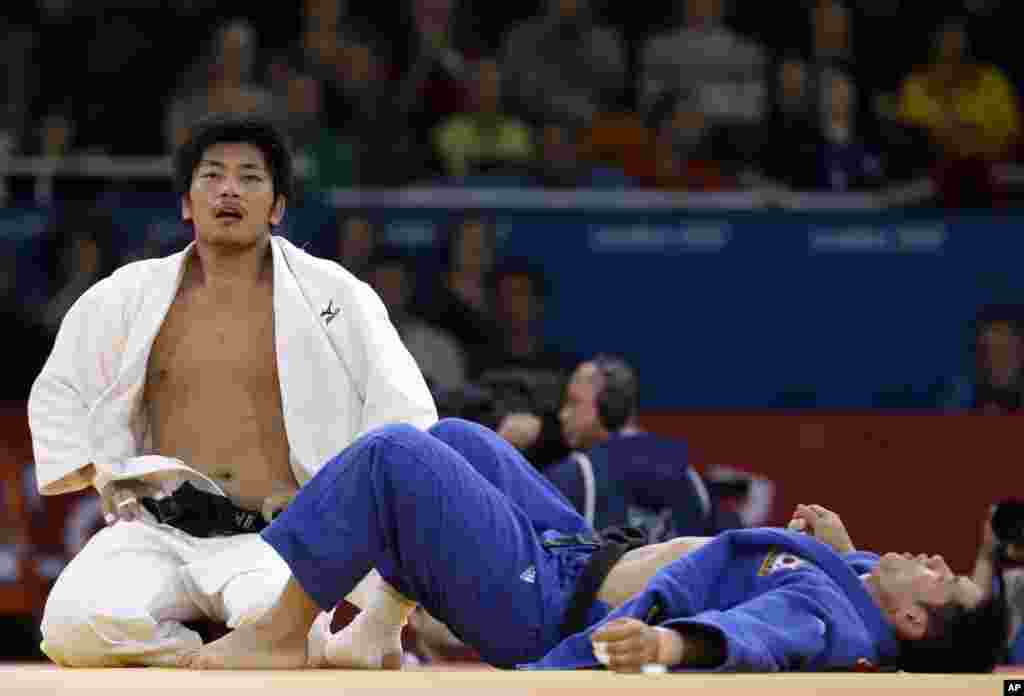 Masashi Nishiyama of Japan, left, and Song Dae-Nam of South Korea, react after their men's 90-kg judo match at the 2012 Summer Olympics, Aug. 1, 2012.