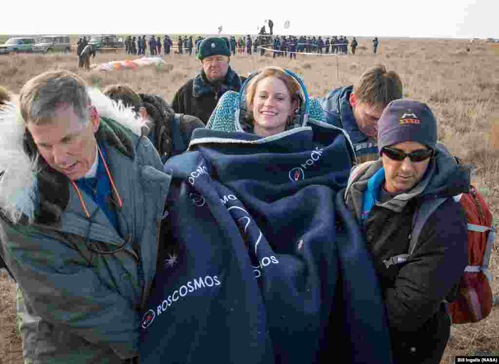 Expedition 49 NASA astronaut Kate Rubins is carried into a medical tent shortly after she, Russian cosmonaut Anatoly Ivanishin of Roscosmos, and astronaut Takuya Onishi of the Japan Aerospace Exploration Agency (JAXA) landed in a remote area near the town of Zhezkazgan, Kazakhstan.