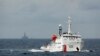 FILE - A Chinese Coast Guard vessel, with the disputed oil rig in the background, is seen in the South China Sea June 13, 2014.