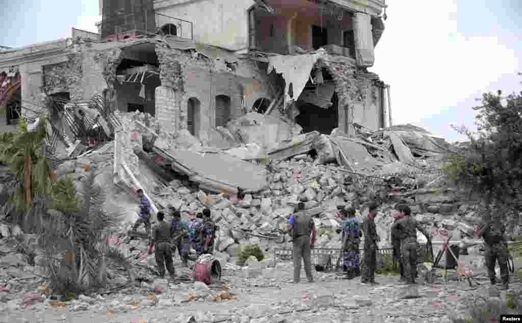 Pasukan setia Presiden Bashar al-Assad berdiri di reruntuhan hotel, bekas markas pasukan Assad di Aleppo, 8 Mei 2014. Pemberontak Suriah meledakkan bom di hotel bersejarah di kota tua Aleppo, Suriah.