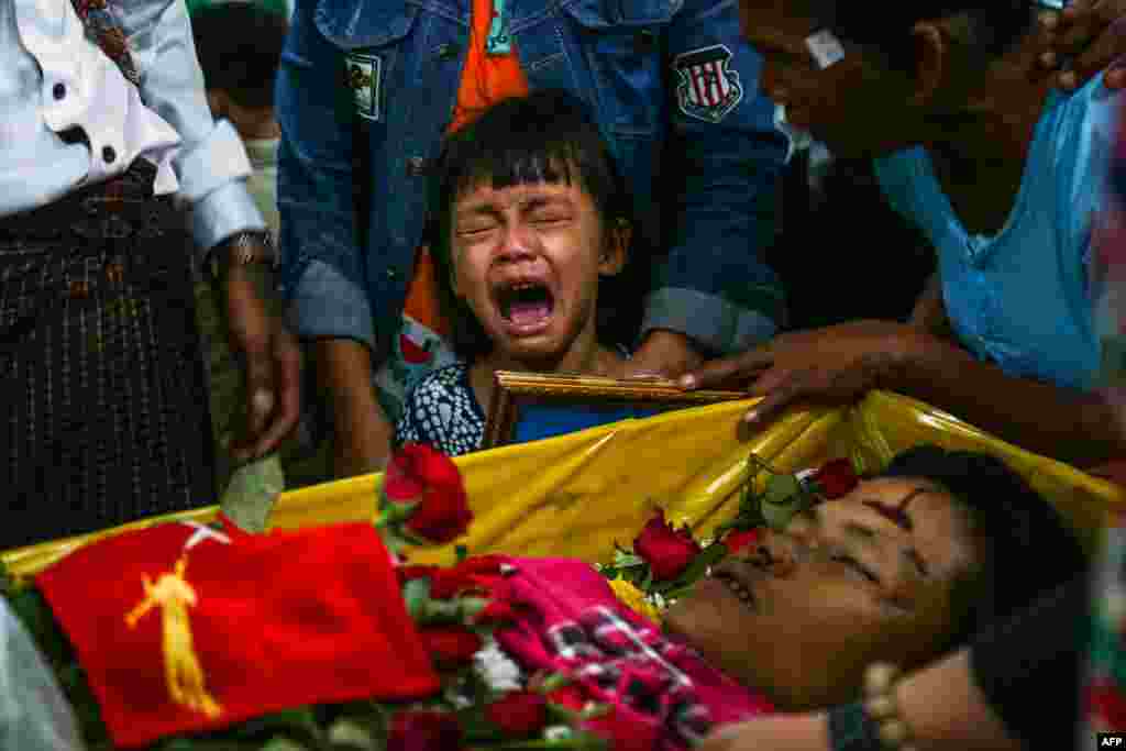 The daughter of Zwee Htet Soe, a protester who died during a demonstration against the military coup on March 3, cries during her father's funeral in Yangon.