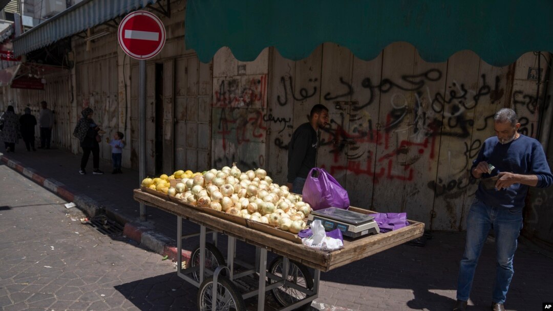 Palestinski prodavac sa tezgom ispred zatvorene prodavnice u Ramali na Zapadnoj obali. 2. maj, 2023. (Foto: AP/Nasser Nasser)