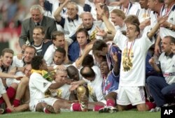FILE - France soccer team celebrate on the pitch with the world cup after they defeated Brazil in the World Cup Final, in Stade de France, in Saint-Denis, Paris, July 12, 1998.