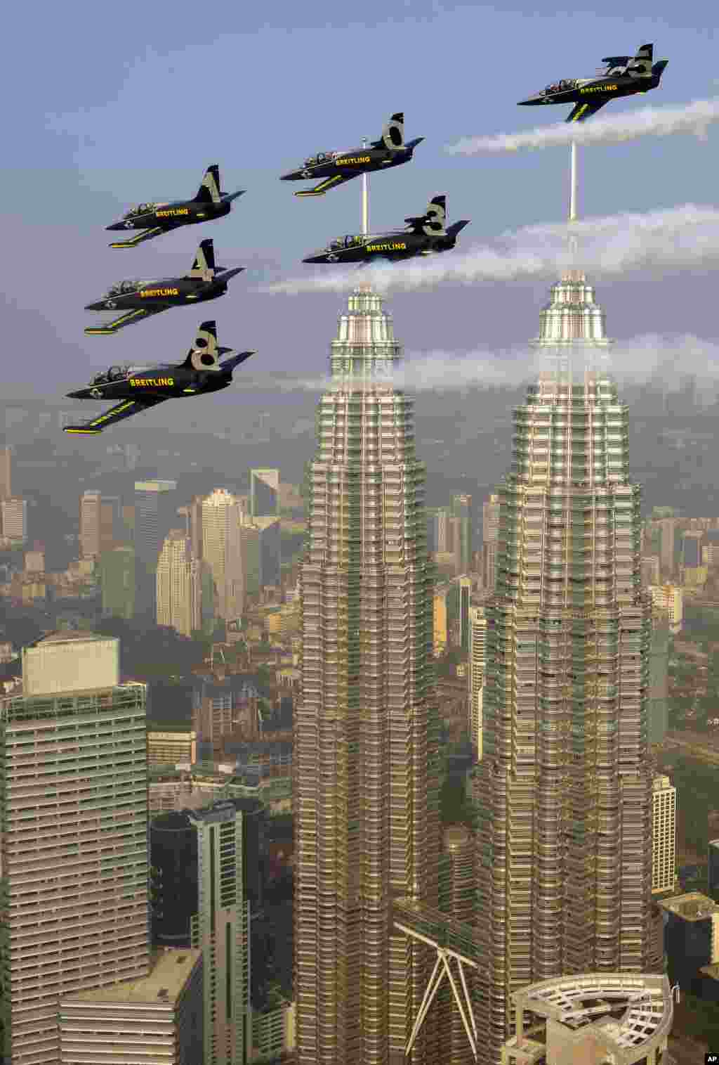 Tim Jet akrobatik Breitling terbang di atas Menara Petronas di atas Kuala Lumpur, Malaysia. Tim Jet akrobatik ini disponsori oleh perusahaan jam tangan mewah Swiss 'Breitling'.