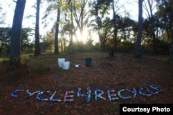 Yana and Slav spell out "Cycle4Recycle" with cans they found in a park