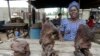 Vivian Koshefobamu, a bushmeat seller, speaks in front of dried bushmeat at the Ajegunle-Ikorodu market in Lagos, Nigeria on August 13, 2014. 