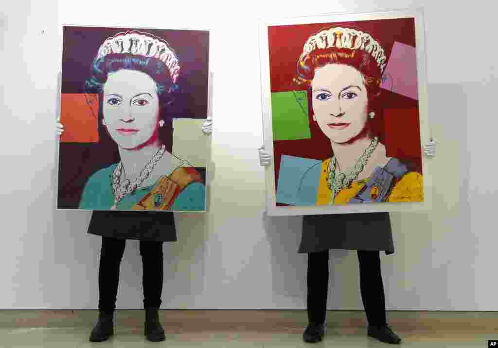 Gallery technicians display screenprints of Queen Elizabeth II by Andy Warhol, at Christie's auction rooms in London. The screenprints will be on sale online until March 31.