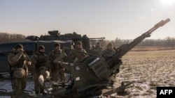 Prajurit Ukraina dari "unit pemburu drone" berdiri di samping autocannon laras ganda anti-pesawat yang mereka gunakan untuk menargetkan drone-drone Rusia di pinggiran Kyiv (foto: dok). 