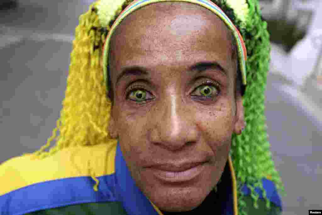 Ana Luiza, wearing contact lenses in the colours of the Brazilian national flag, poses on a street in Sao Paulo, March 23, 2014.