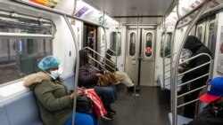 USA, New York, People wearing face masks are seen in a train cabin at the Times Square subway