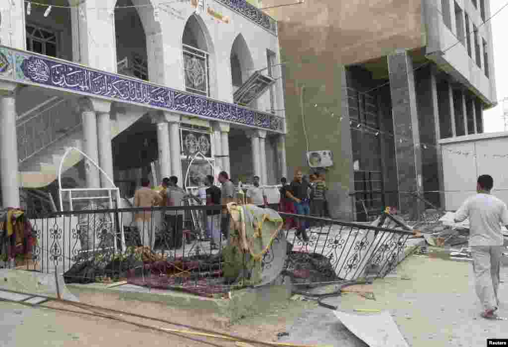 Onlookers gather outside Zain al-Abideen mosque, a Shi'ite place of worship, near where a suicide bomb attack occurred, Hilla, Iraq, May 21, 2013.