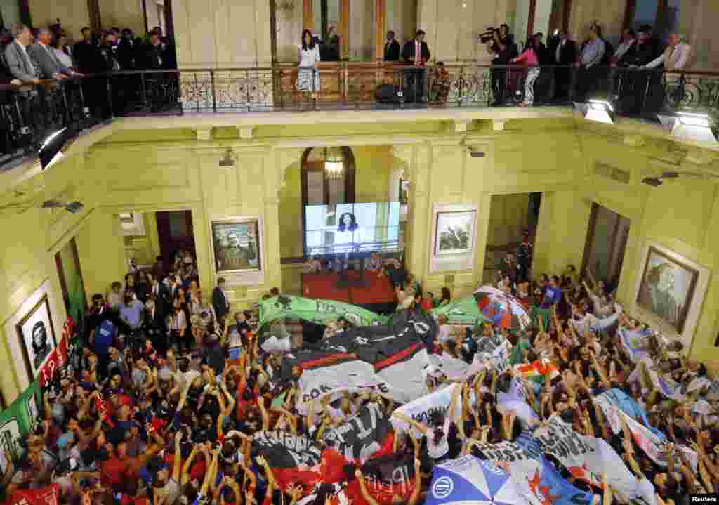 Presiden Argentina Cristina Fernandez de Kirchner (tengah atas) melambai kepada warga yang menyambutnya di gedung pemerintah di Buenos Aires.