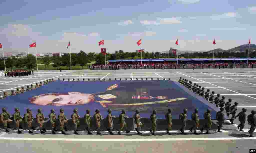 Pasukan tentara Turki membawa spanduk raksasa yang menampilkan potret Mustafa Kemal Ataturk, pendiri Turki modern, dalam parade yang menandai perayaan 91 tahun Hari Kemenangan di Ankara.