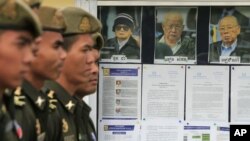 Cambodian military officials line up in front the top leaders of Khmer Rouge portraits, from right, former Khmer Rouge Foreign Minister Ieng Sary, former Khmer Rouge head of state Khieu Samphan, and former Deputy Secretary Nuon Chea, file photo. 