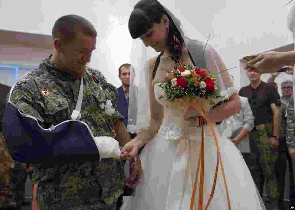 Komandan peleton Republik Rakyat Donetsk Arsen Pavlov, juga dikenal sebagai Motorola, dan Elena Kolenkina saling menukar cincin dalam upacara pernikahan mereka di kota Donetsk, Ukraina Timur. 