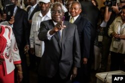 FILE - Afonso Dhlakama shows his ink-stained finger after casting his ballot at a polling station in Maputo.