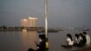 FILE - People uses their mobile phones on the Tonle Sap riverside in Phnom Penh, Cambodia, Feb. 18, 2021.