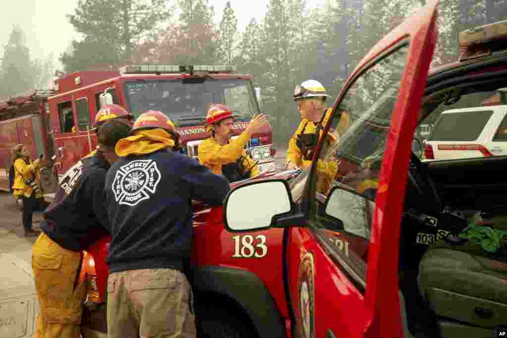 Firefighters plan their operations while battling the Camp Fire in Paradise, Calif., Nov. 10, 2018.
