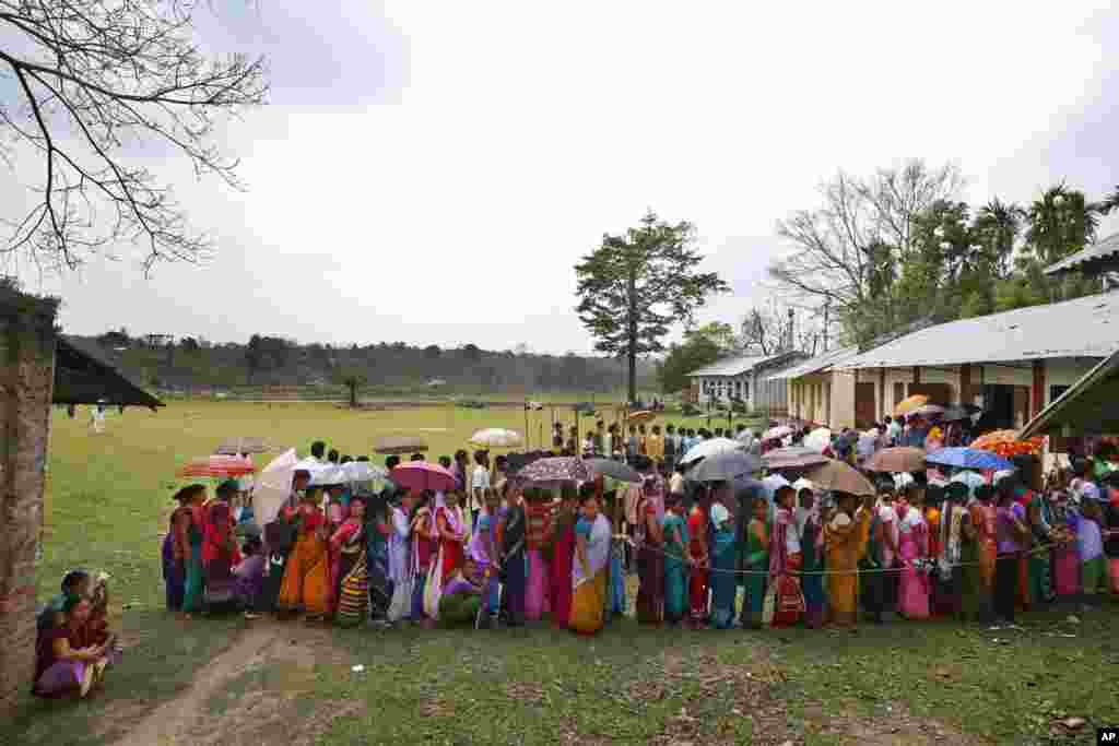 People stand in queue to cast their votes during the first phase of elections in Mandai, in the northeastern state of Tripura. India started the world's largest election Monday, with voters in the remote northeast making their way past lush rice paddies and over rickety bamboo bridges to reach the polls.