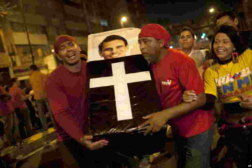 Người ủng hộ ông Hugo Chavez giả vờ đưa tang ứng cử viên đối lập Henrique Capriles trong lúc ăn mừng chiến thắng ở trung tâm thủ đô Caracas.