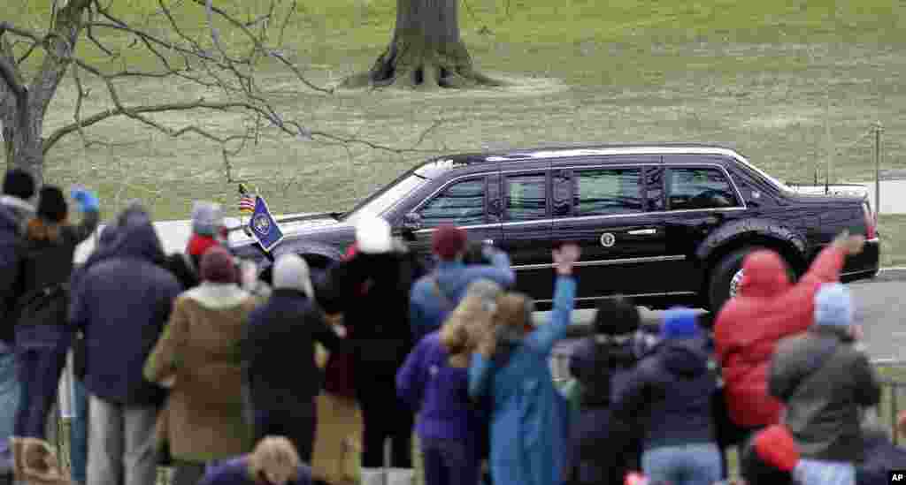 People wave at President Barack Obama and Vice President Joe Biden as their limousine passes Monday, Jan. 21, 2013, in Washington.