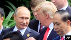 Presiden Russia Vladimir Putin dan Presiden AS Donald Trump berbincang saat sesi foto bersama di KTT APEC di Danang, Vietnam, 11 November 2017.