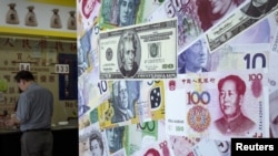 FILE - Customer is served at a foreign exchange store in Hong Kong, China, Aug. 13, 2015. 