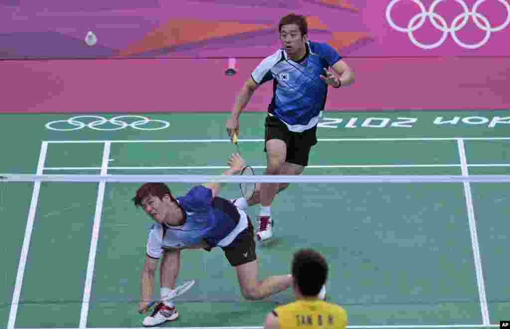 South Korea's Chung Jae-sung, right, and Lee Yong-dae play against Malaysia's Koo Kien Keat, unseen, and Tan Boon Heong, at a men's doubles badminton match of the 2012 Summer Olympics, July 31, 2012.