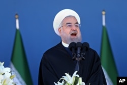 FILE - Iran's President Hassan Rouhani speaks at a military parade marking National Army Day in front of the mausoleum of the late revolutionary founder Ayatollah Khomeini, just outside Tehran, April 17, 2016.