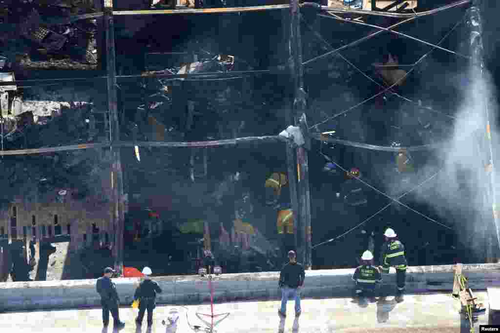 Firefighters work inside the burned warehouse following the fatal fire in the Fruitvale district of Oakland, California, Dec. 4, 2016.
