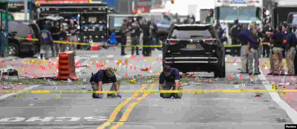 Federal Bureau of Investigation (FBI) officials mark the ground near the site of an explosion in the Chelsea neighborhood of Manhattan, New York, injuring 29 people late Saturday. Authorities called the blast "an intentional act."