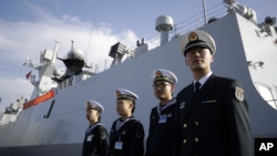 FILE - Chinese Navy officials stand in front of the ship Daqing.