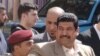 A Baghdad voter is searched before entering a polling station, 7 March 2010