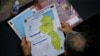  Un miembro de la Asamblea Nacional sostiene un mapa que muestra la disputada región del Esequibo como parte de Venezuela, mientras las tensiones entre Caracas y Guyana han aumentado en las últimas semanas, el 6 de diciembre 2023. 