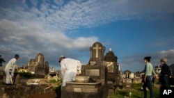 Relatives attend the burial service of 89-year-old Irodina Pinto Ribeiro, who died from complications related to COVID-19, at the Inhauma cemetery in Rio de Janeiro, Brazil, June 18, 2021.