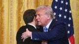 Дональд Трамп и Эммануэль Макрон завершают пресс-конференцию в Белом доме дружескими объятиями. 24 февраля 2025 года. (Photo by ROBERTO SCHMIDT / AFP).